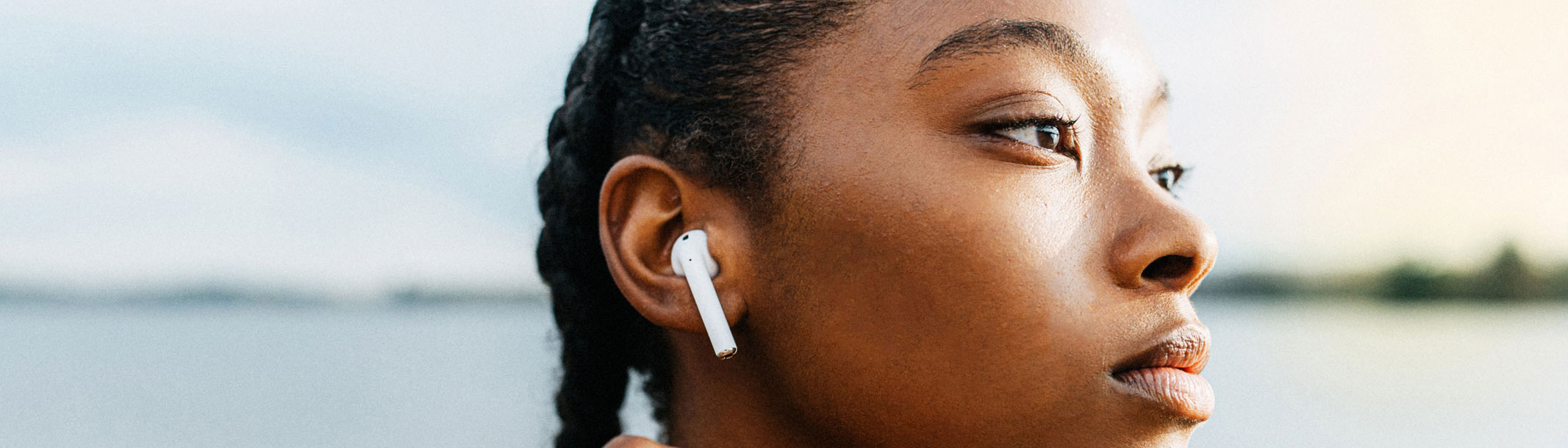 A close-up picture of a young woman wearing sports earbuds
