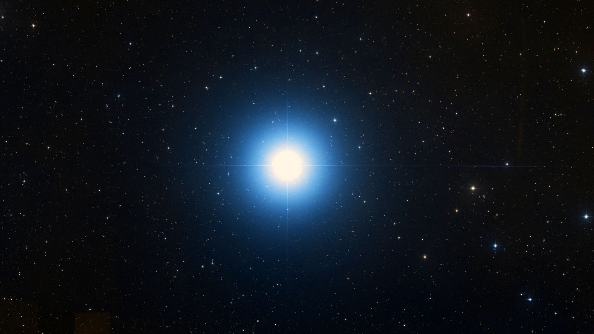 A bright blue star is pictured shining in a black sky surrounded by lesser stars.
