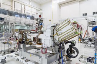 NASA's Perseverance rover during launch preparations, with space for the rover's nuclear power source on display.