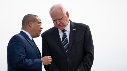 Minnesota Attorney General Keith Ellison and Minnesota Governor Tim Walz await the arrival of US Vice President Kamala Harris at the Minneapolis-St. Paul International Airport