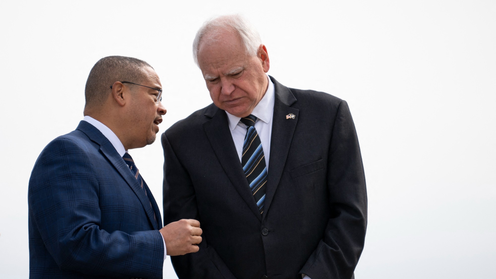 Minnesota Attorney General Keith Ellison and Minnesota Governor Tim Walz await the arrival of US Vice President Kamala Harris at the Minneapolis-St. Paul International Airport 