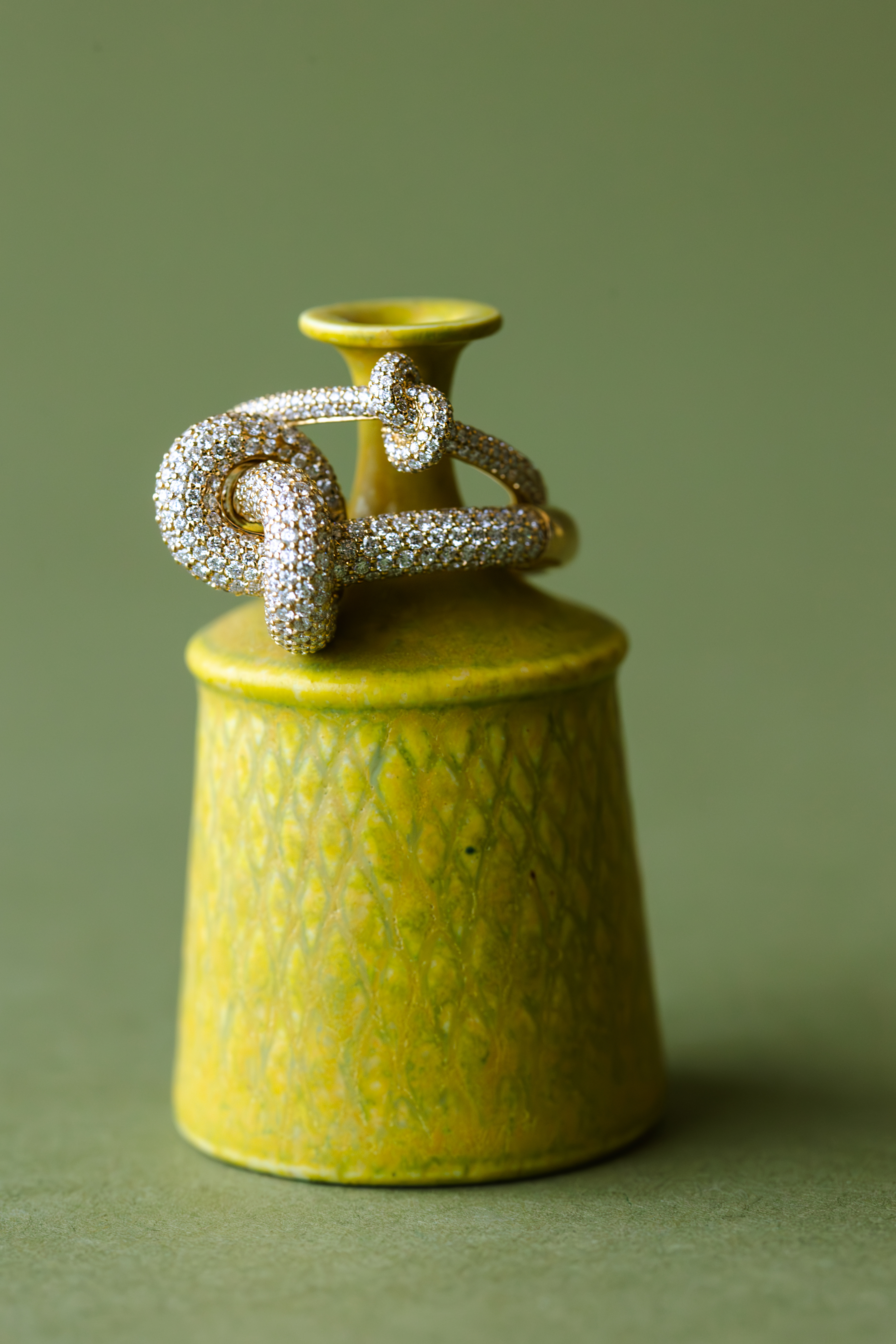 ceramics and jewellery against green and brown backgrounds