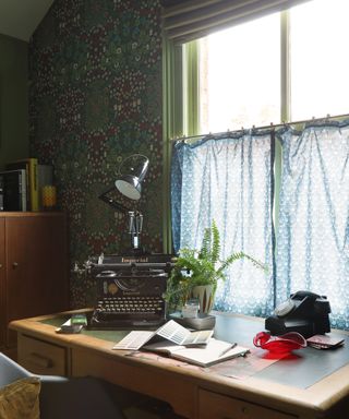 vintage style home office with traditional typewriter and phone on desk and cafe curtains