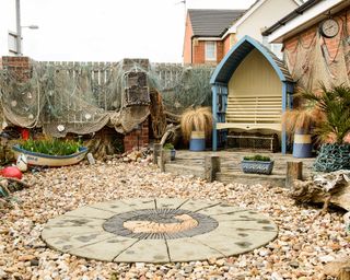 beach themed garden with pebbles and arbor