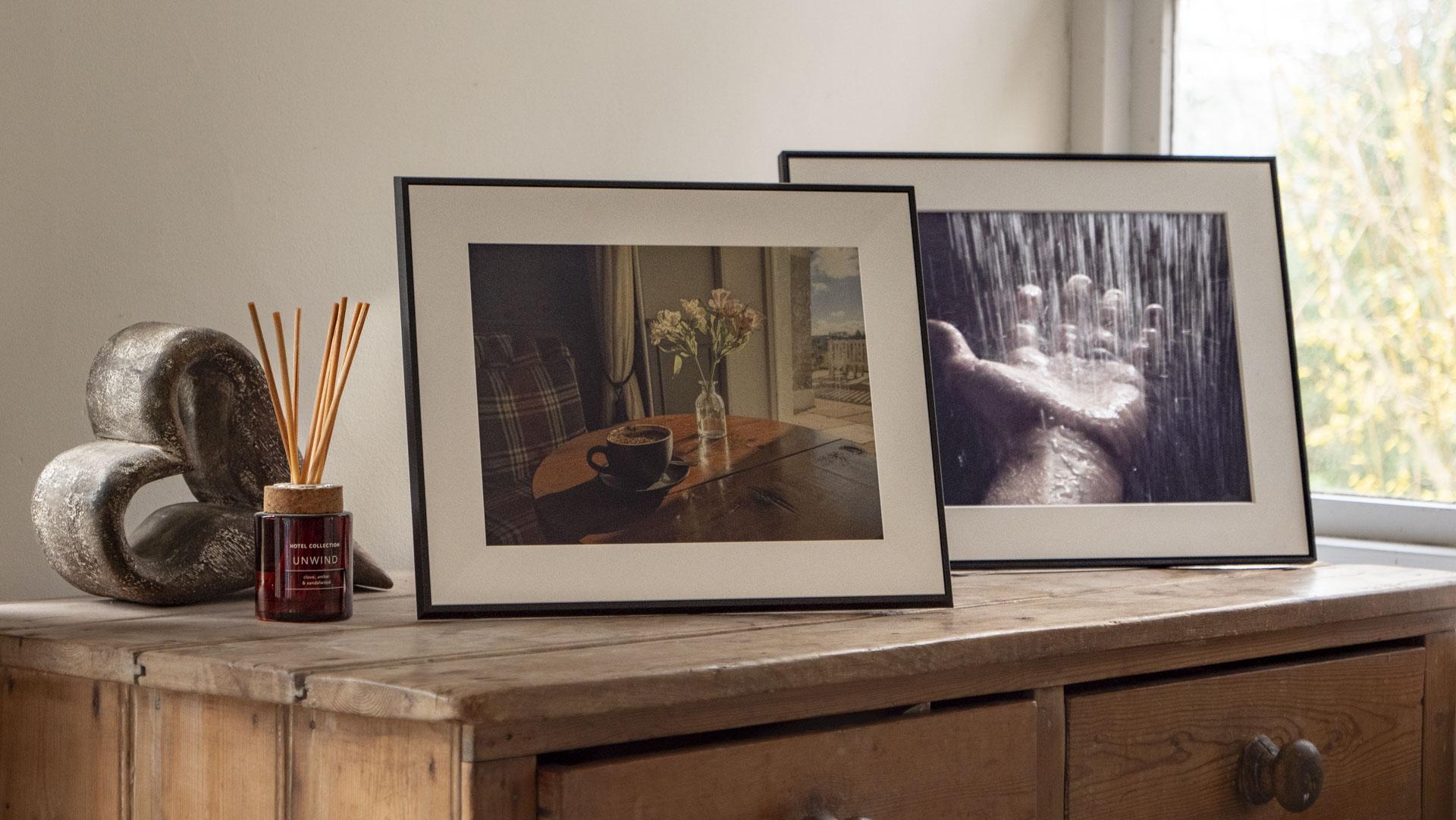 The Aura Ink 'E Ink' digital photo frame on a sideboard, alongside the Aura Walden frame