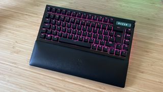 Razer BlackWidow V4 Pro 75% with wrist rest attached on a wooden desk