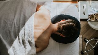 Woman lying face down on massage table at spa