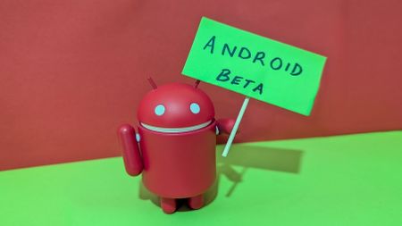 Small red Android figurine holding a green sign that read "Android Beta"