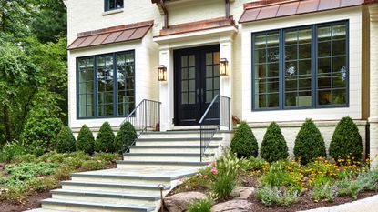 a front of a painted house with small shrubs