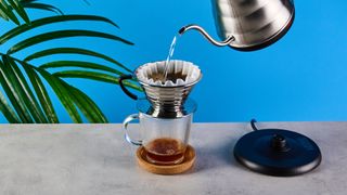 kalita wave stainless steel pour-over coffee dripper photographed against a blue background with kalita filters