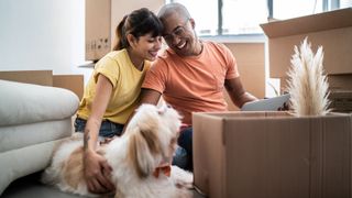 Couple sitting on the floor pet dog by their side