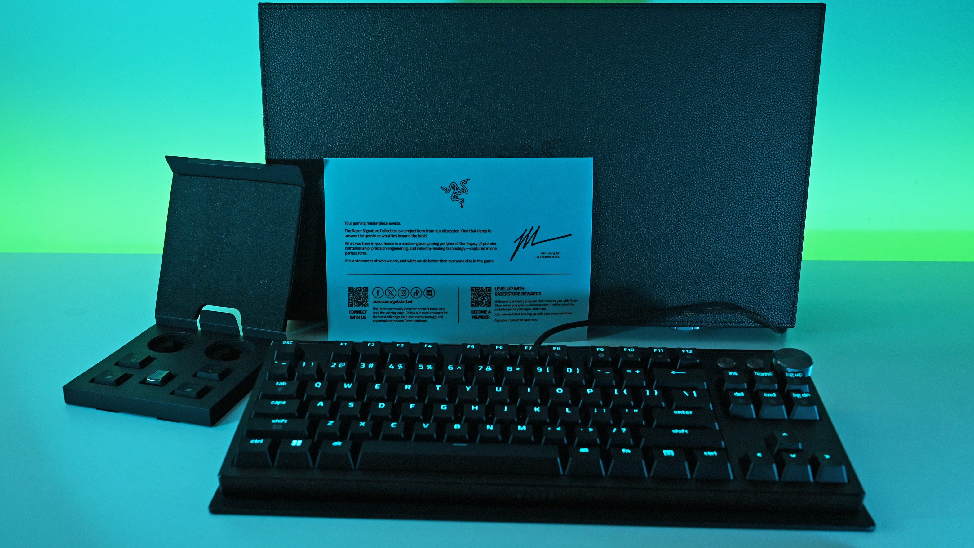 The Razer Huntsman Signature Edition keyboard displayed with its premium black box, a welcome card signed by Min-Liang Tan, and extra keycaps.