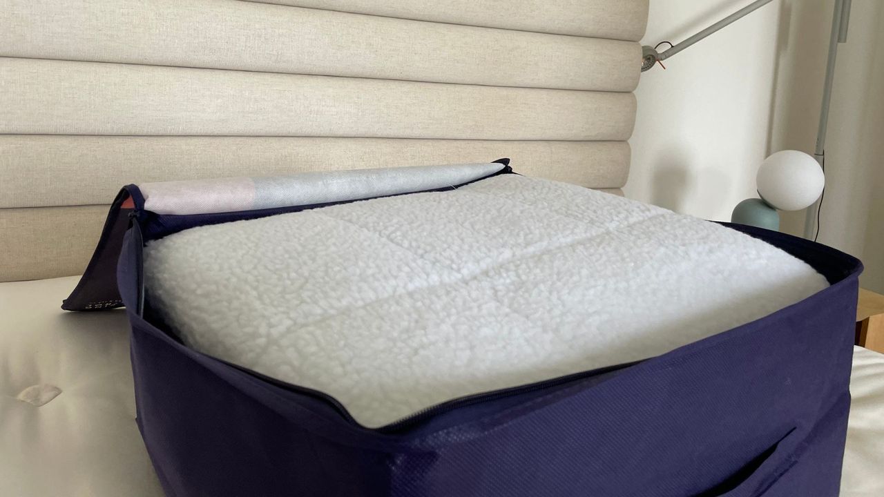 Dreamland Hunker Down Skandi Sherpa Blanket in its bag on a bed
