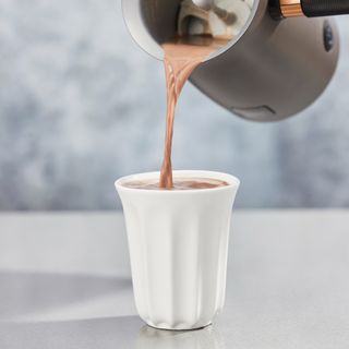 Hotel Chocolat Velvetiser pouring hot chocolate into white mug