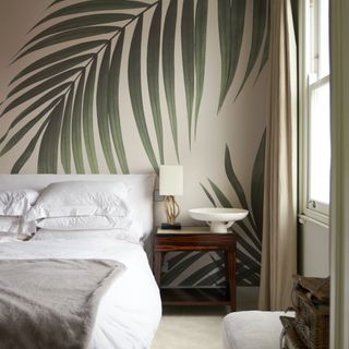 White bed with tropical leafy wallpaper