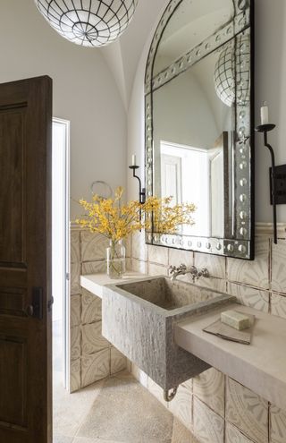 Small bathroom with large mirror, beige tile and stone sink