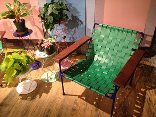 Green folding chair next to some plants