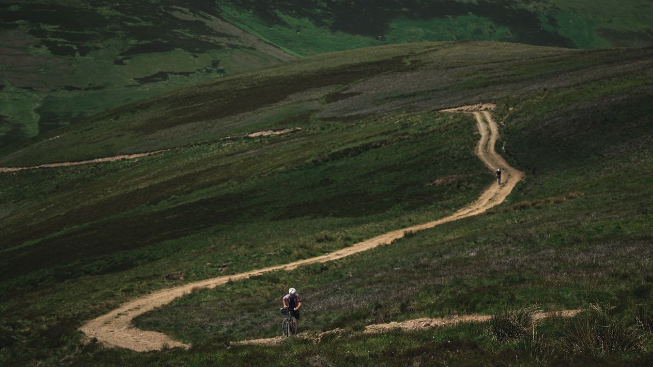 Two cyclist ride up a steep gravel climb