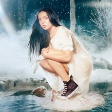 Charli XCX wears a white gown and a Pair of sneakers