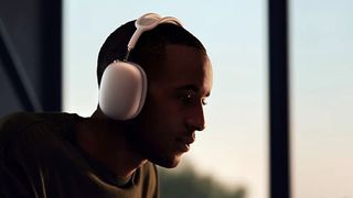 AirPods Max worn by a man silhouetted against the sunset