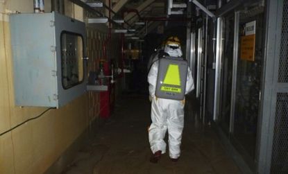 Workers wearing protective suites enter Unit 2 of the Fukushima Daiichi plant: Tokyo Electric said Tuesday that additional meltdowns likely occurred at Units 2 and 3.