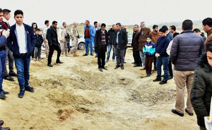 Iraqi Kurds inspect a crater reportedly caused by an Iranian missile.