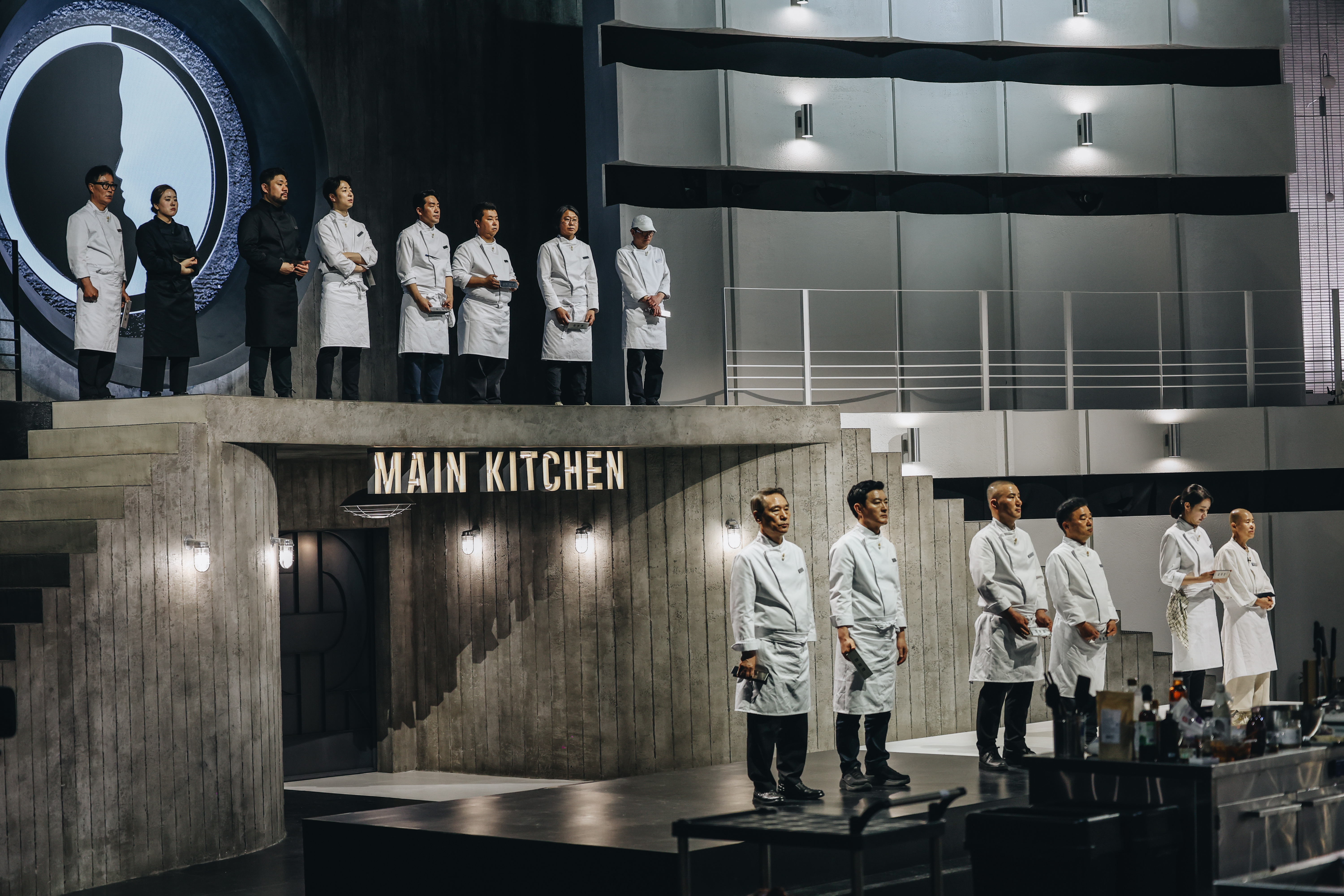 the finalist chefs in white and black chef coats stand before the judges in culinary class wars season 2