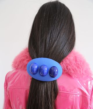 Woman's hair held back by a big blue clip