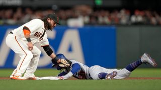 Mookie Betts #50 of the Los Angeles Dodgers steals second base against Brandon Crawford #35 of the San Francisco Giants during the sixth inning in game 5 of the National League Division Series at Oracle Park on Oct. 14, 2021 in San Francisco, California.