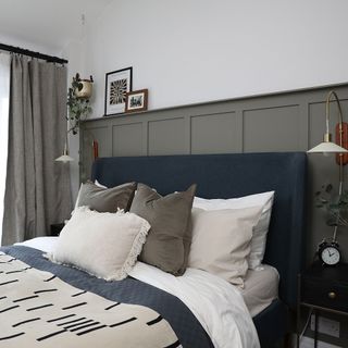 Bed with upholstered frame against grey panelling