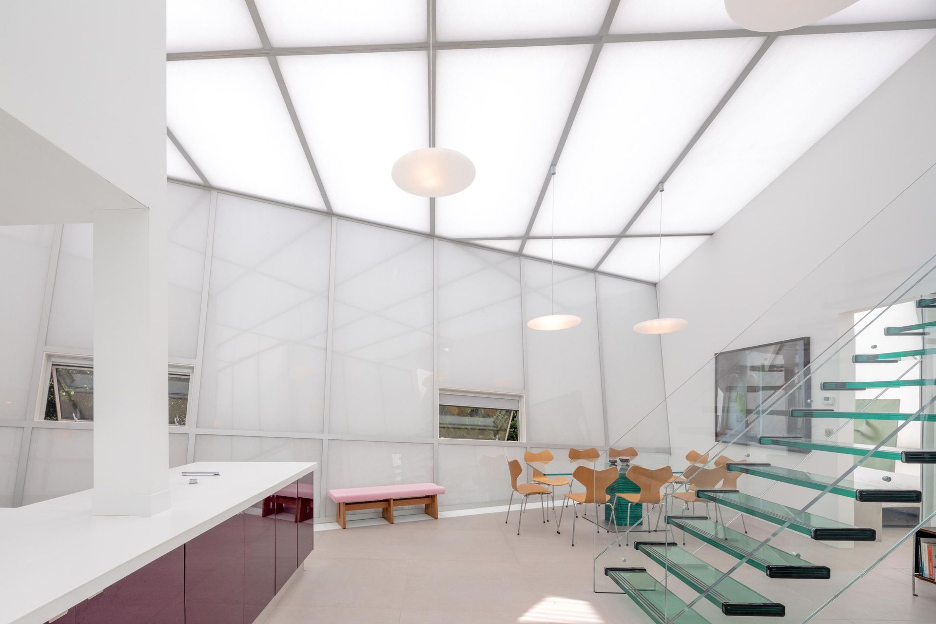 Salle à manger blanche avec escalier en verre chez Maison de Verre par Studio Odile Decq (photo Philippe Ruault)
