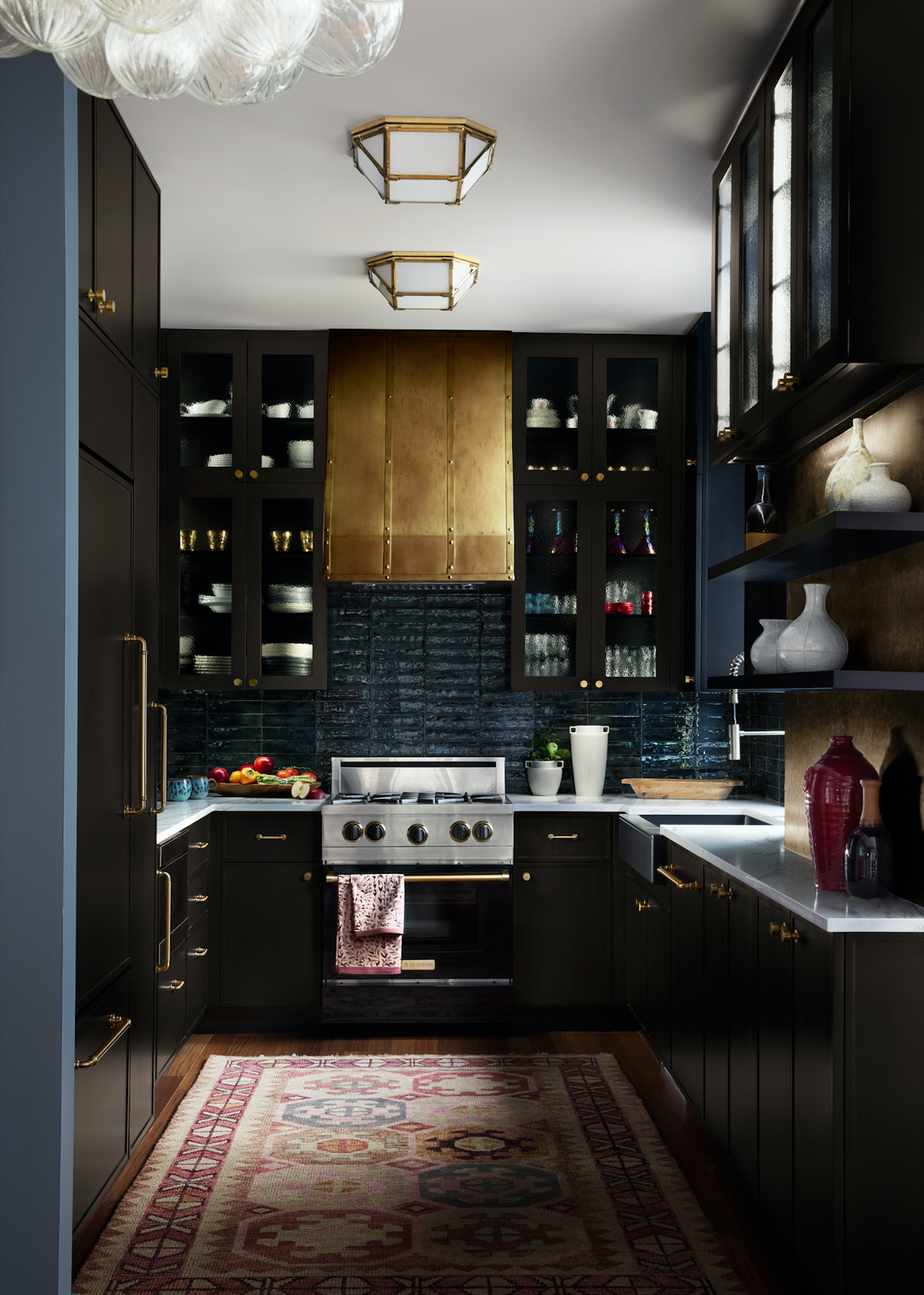 dark kitchen with brass hood and colourful rug