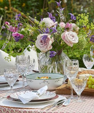 A close-up shot of an outdoor dining table with glassware and crockery