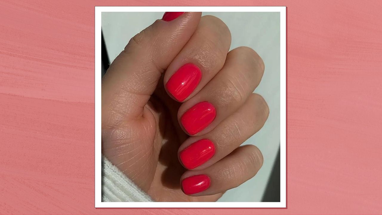 A hand with pink-red &#039;watermelon nails&#039; by nail artist @gel.bymegan/ in a pink-red template