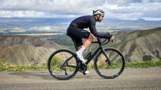 A black pinarello against a background of mountains
