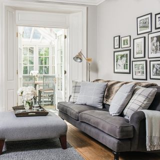 living area with white wall and grey sofa