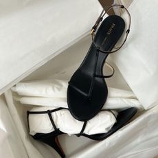 A pair of black Khaite heels in a box.