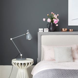 bedroom with grey walls bed and pink cushions
