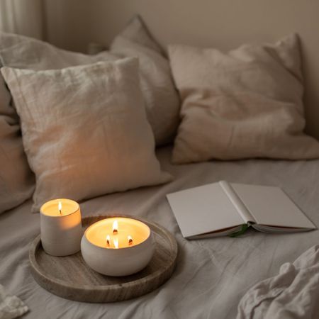 Evening candle situated on a cosy-looking bed