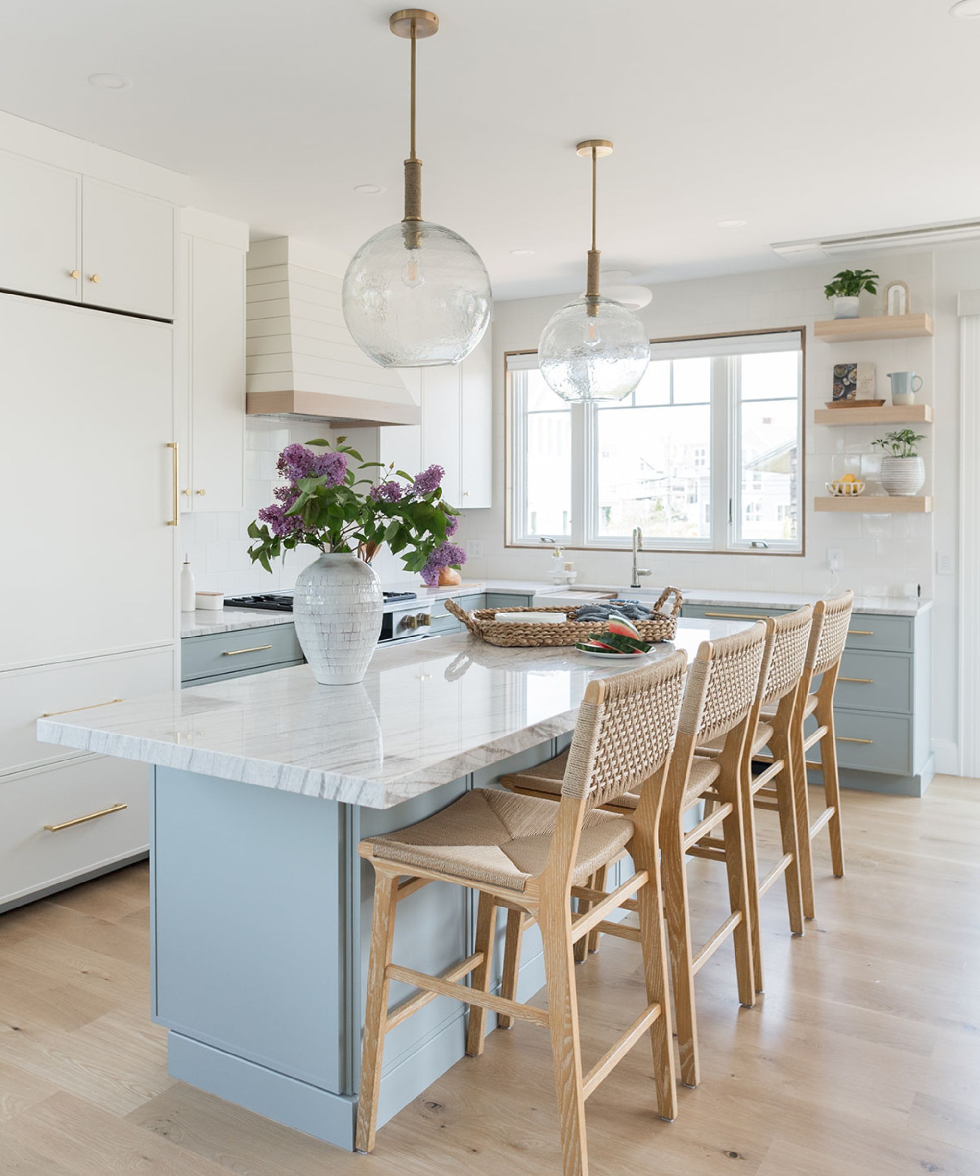 A blue and white kitchen with marble countertops