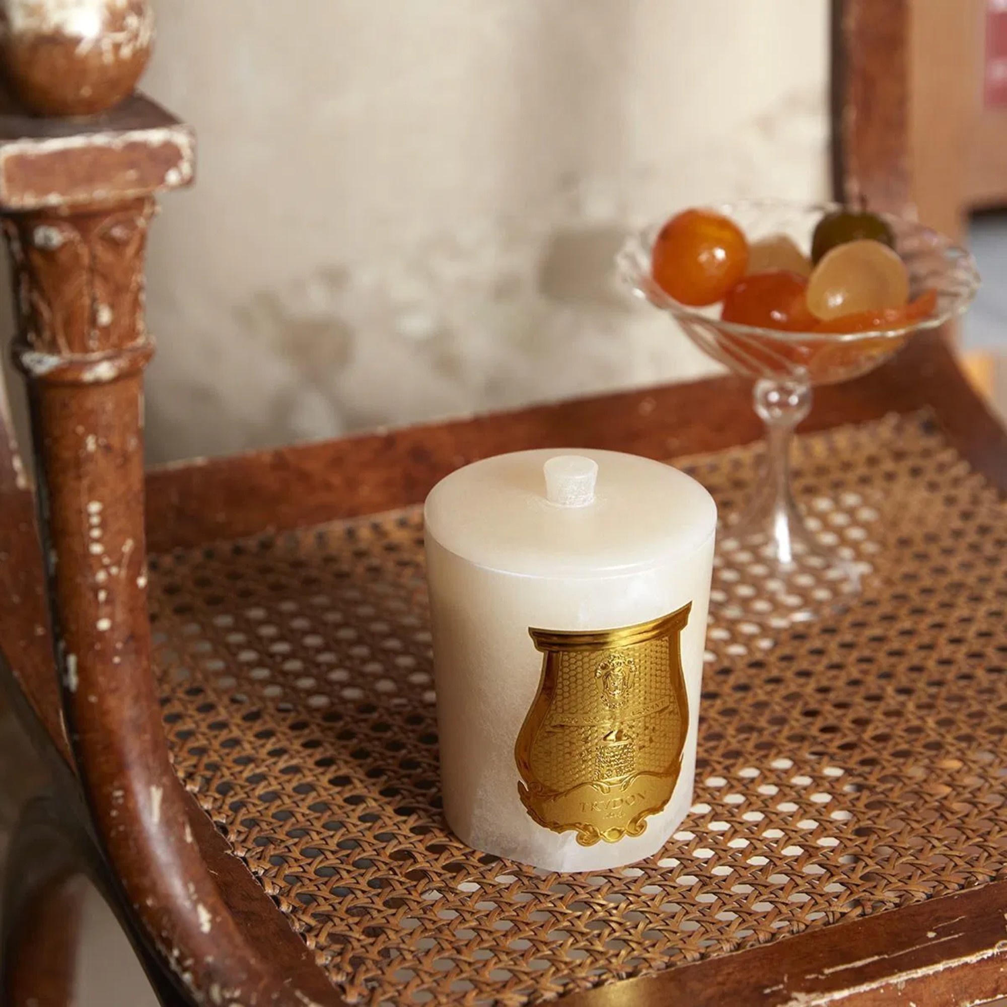 Cire Trudon Ernesto The Alabasters candle on a vintage rattan chair