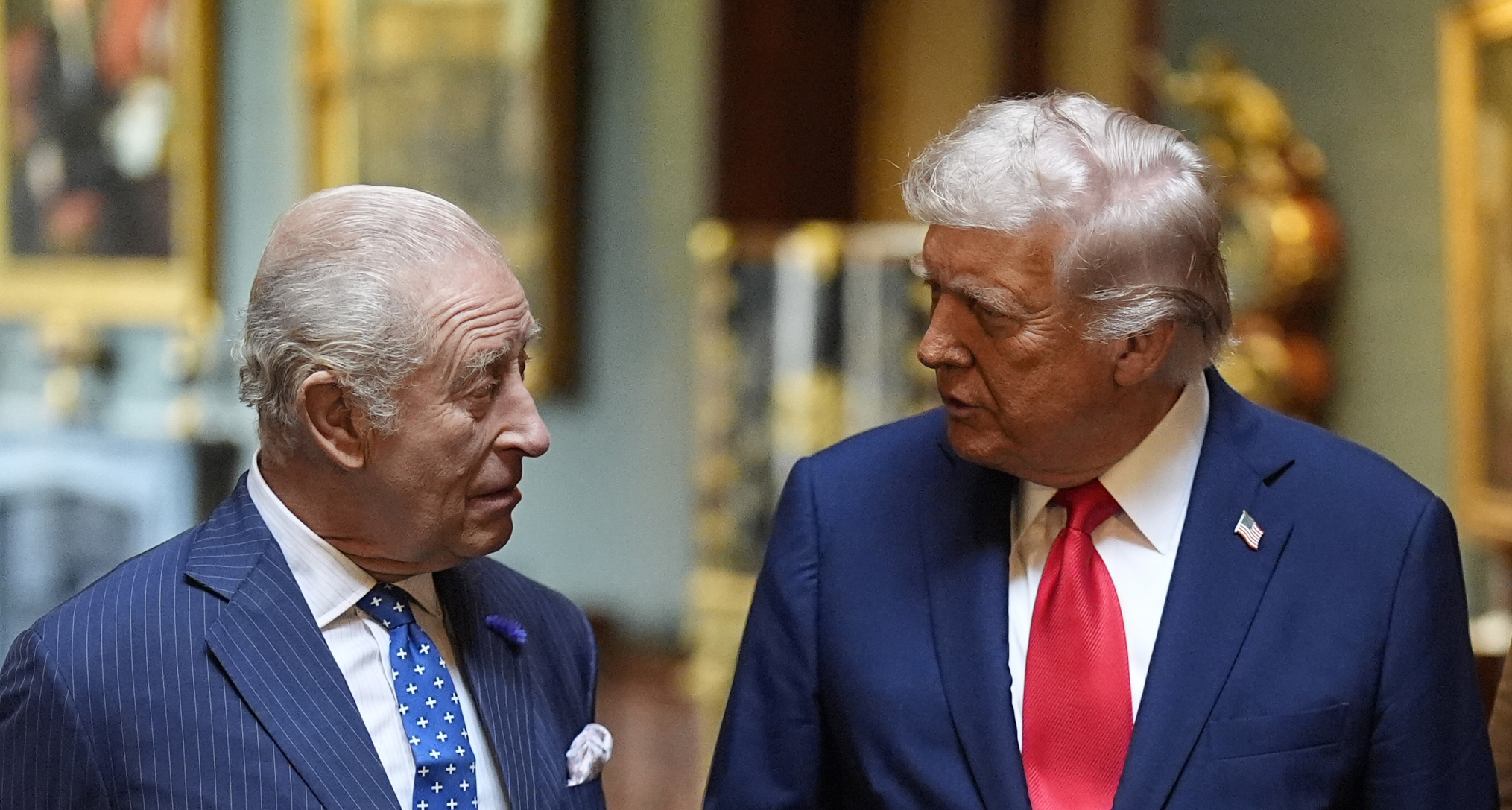 King Charles and Donald Trump talking to each other wearing blue suits