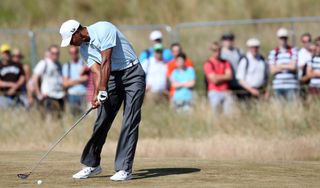 Tiger Woods strikes an iron shot from the fairway