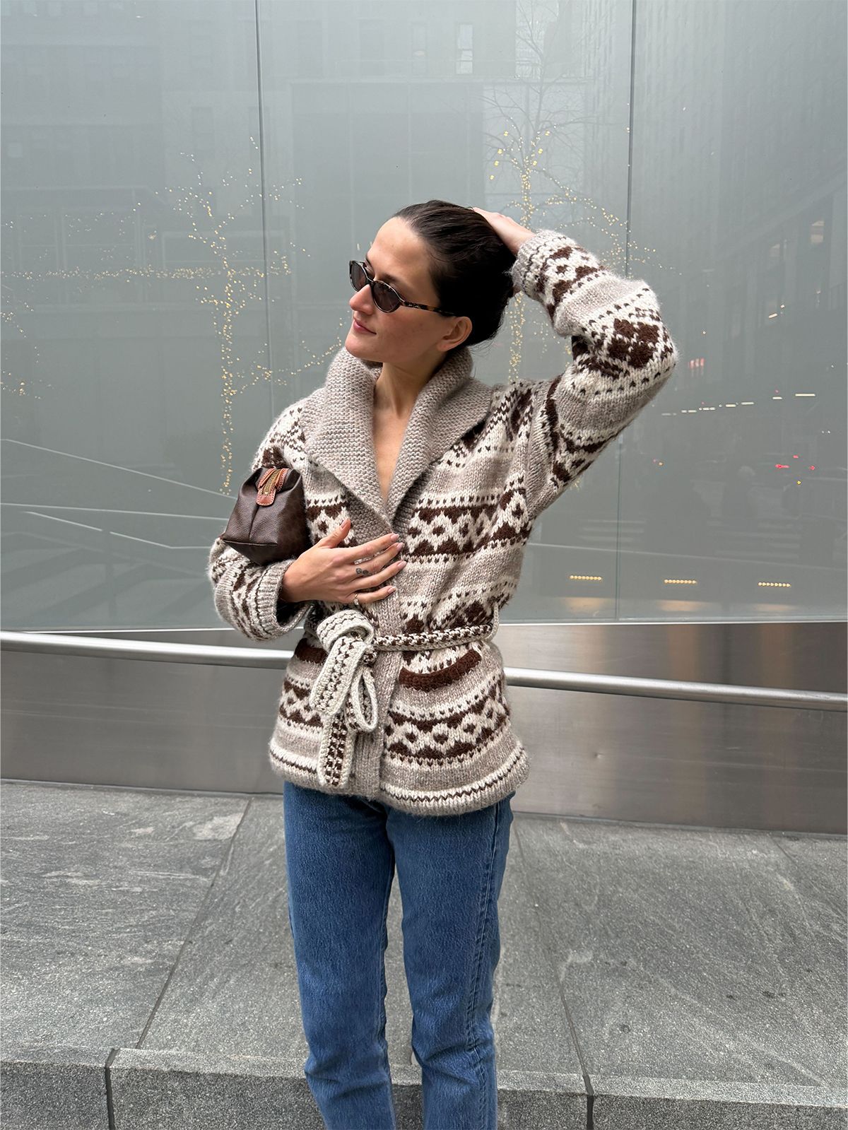 Eliza Huber wearing the Doen Hale Cardigan with jeans and a brown Celine clutch bag.