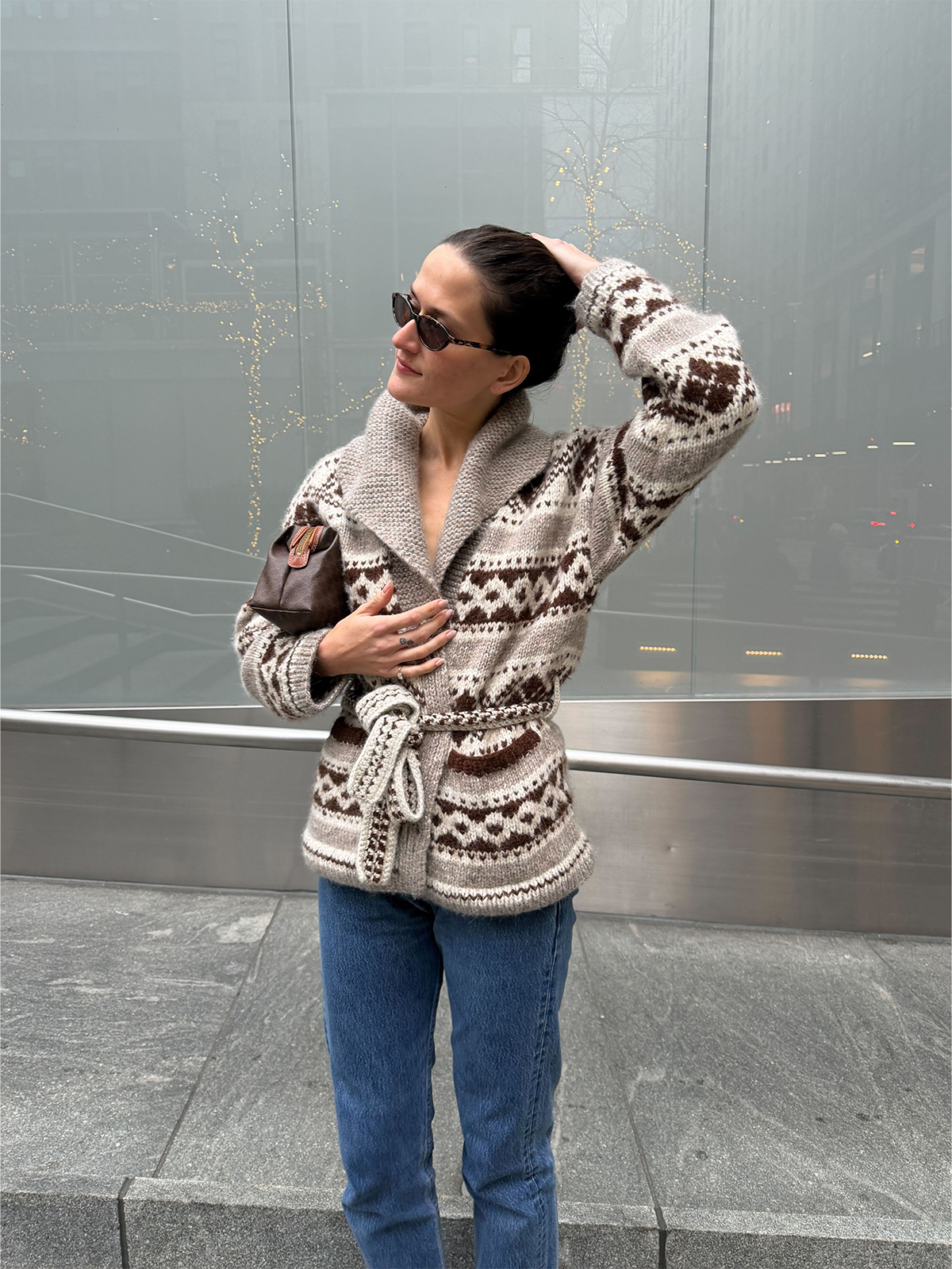 Eliza Huber wearing the Doen Hale Cardigan with jeans and a brown Celine clutch bag.