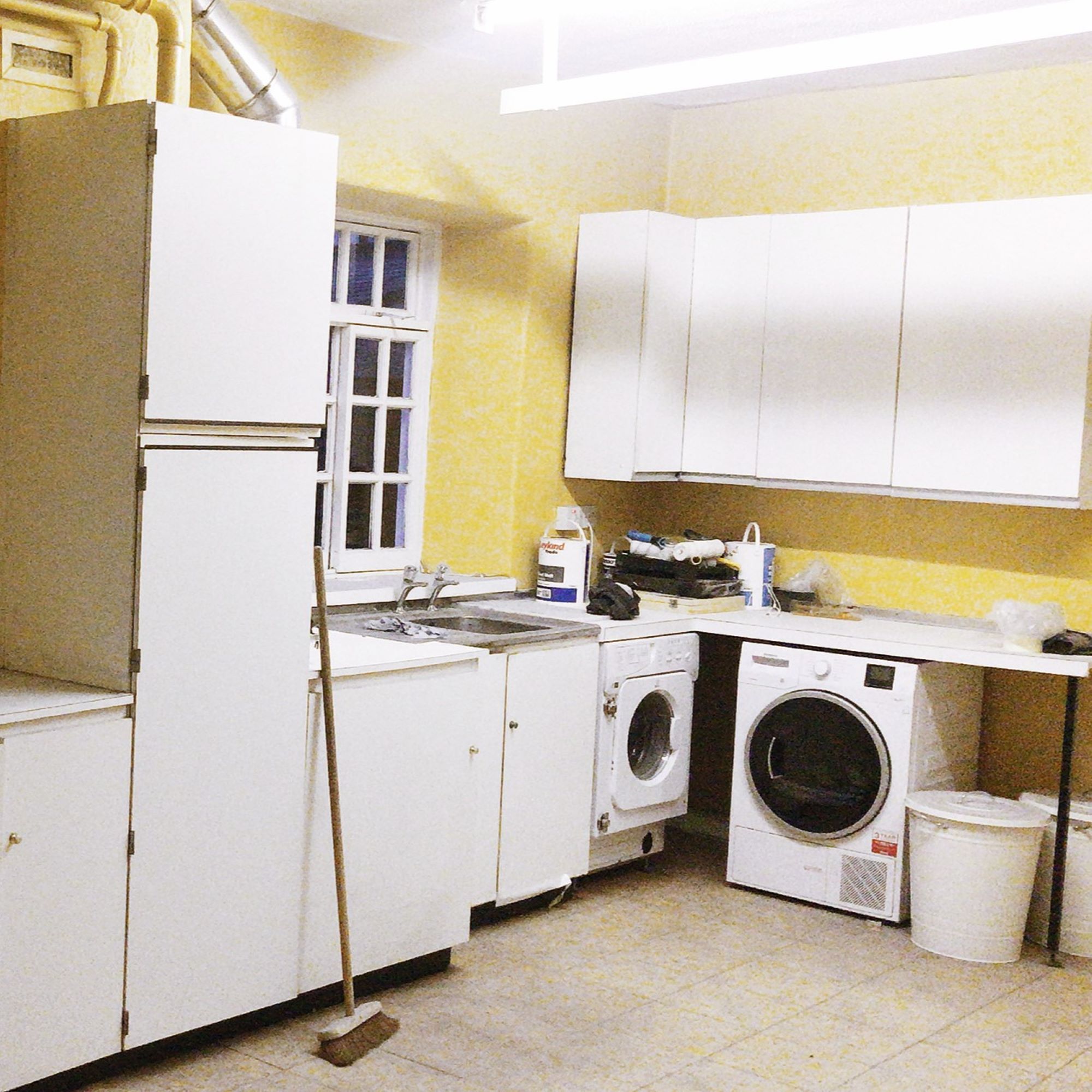 yellow utility room with washing machine