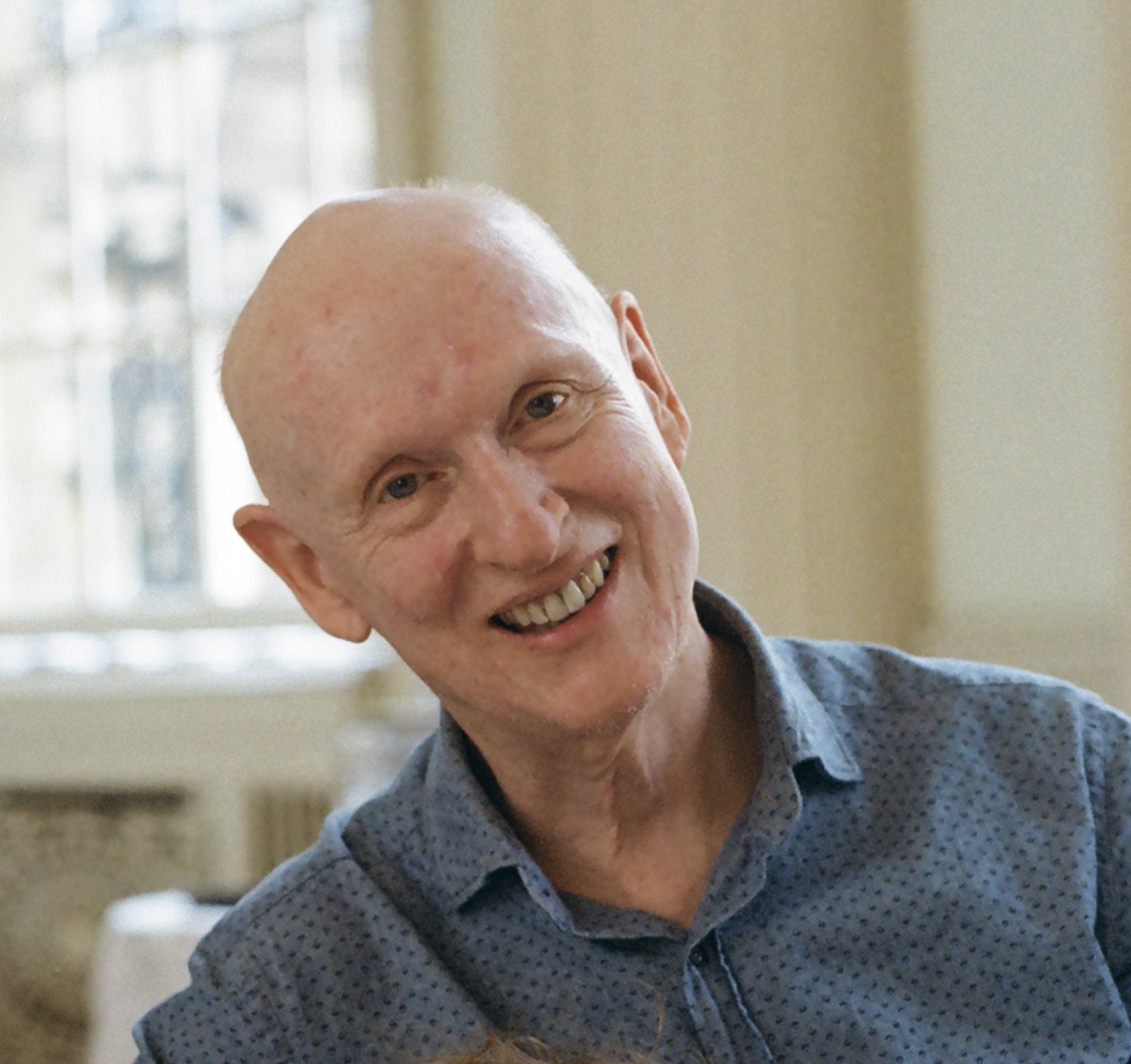 bald man smiles to camera