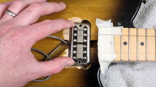Man routs a guitar body to accept a humbucker pickup