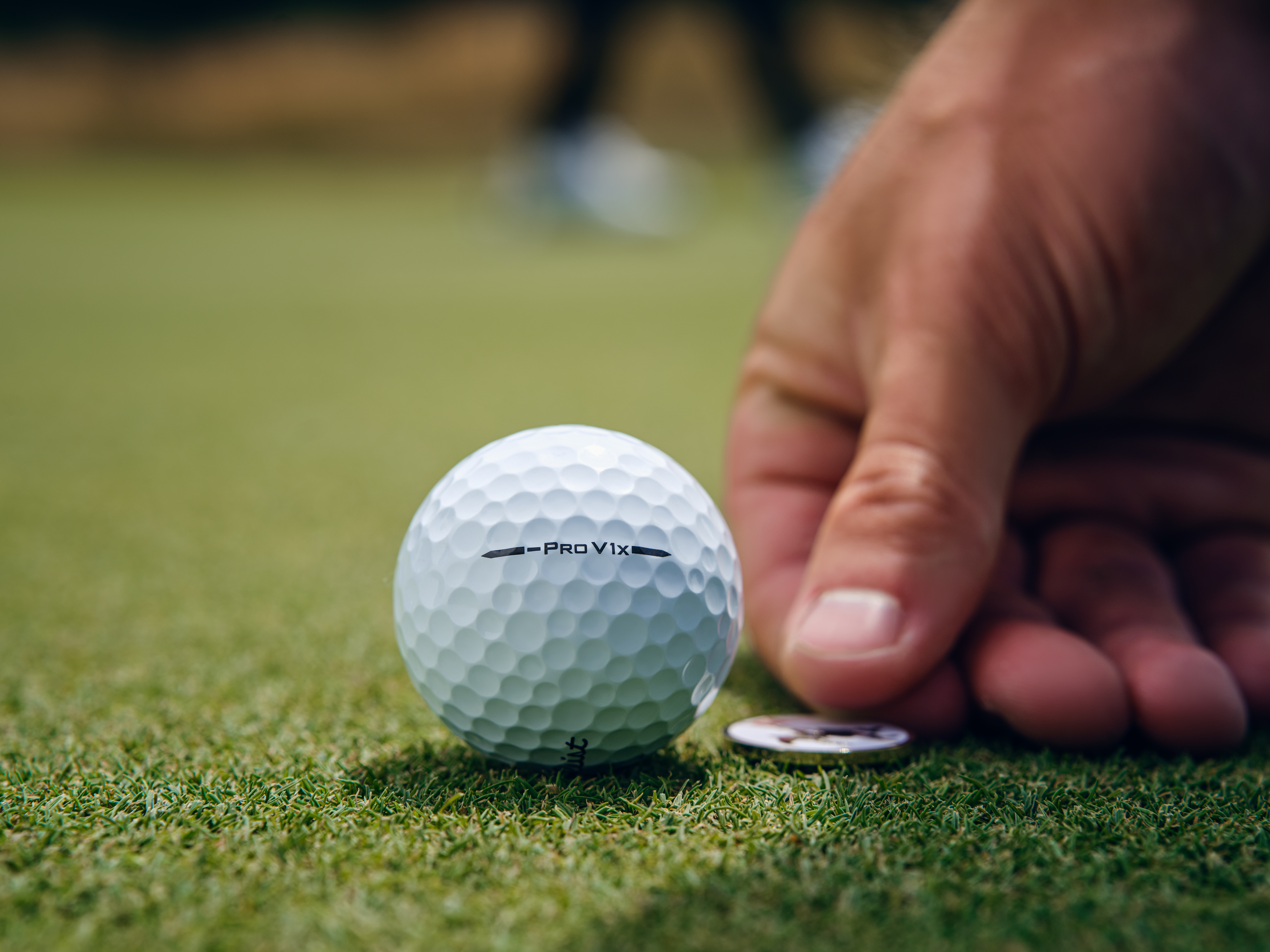 A golfer puts a marker behind the Titleist Pro V1x Left Dash