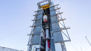 a rocket stands upright inside a hangar